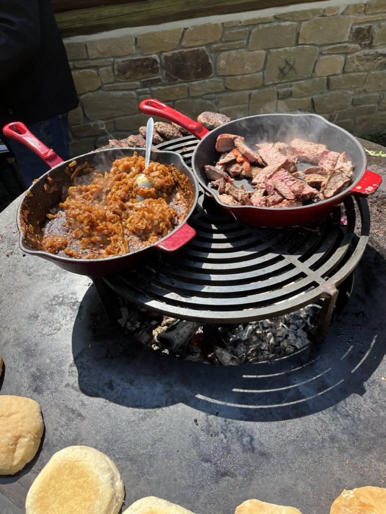 Cocottes et viande qui cuisent au-dessus d’un feu de bois