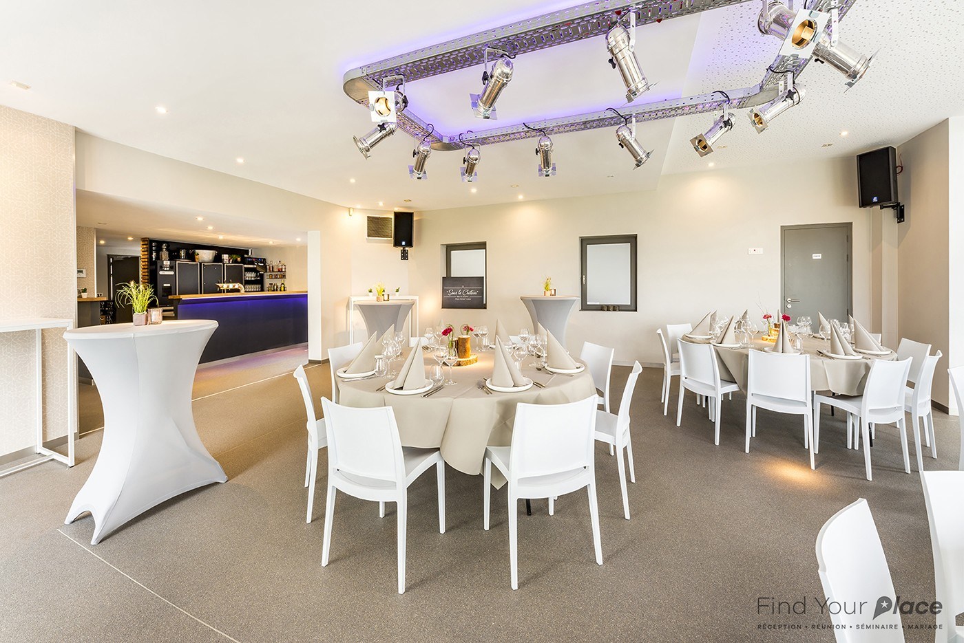 Tables dressées et espace bar dans la salle